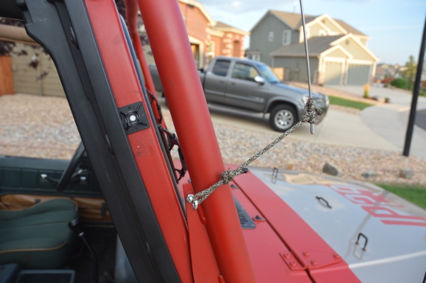 Antenna tie down with eye bolt on light bar.